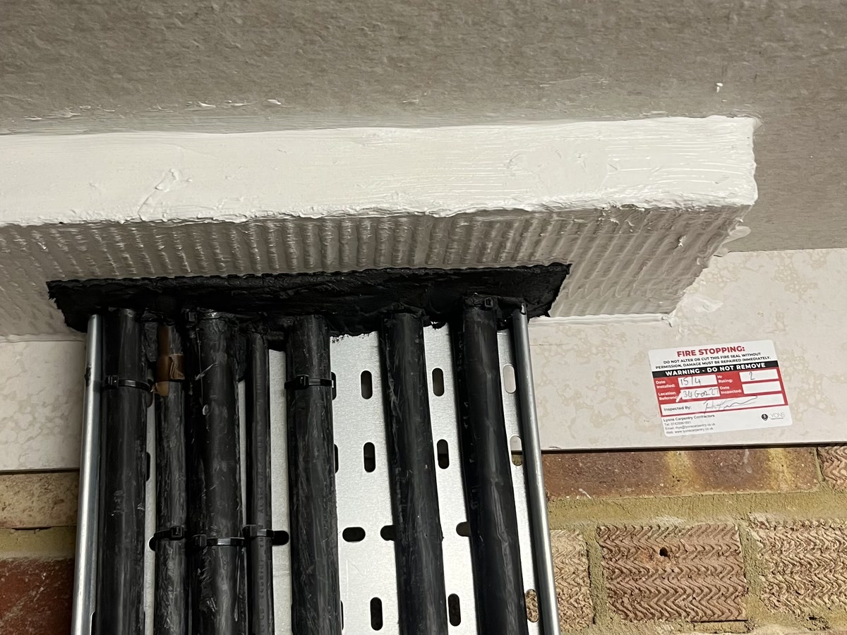 Fire-stopped service penetration with ablative batt seal and Lyons inspection label